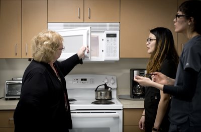 Student helping a senior with their microwave