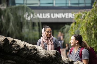 students walking on bridge outside salus