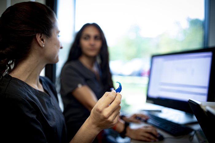 student holding hearing aid