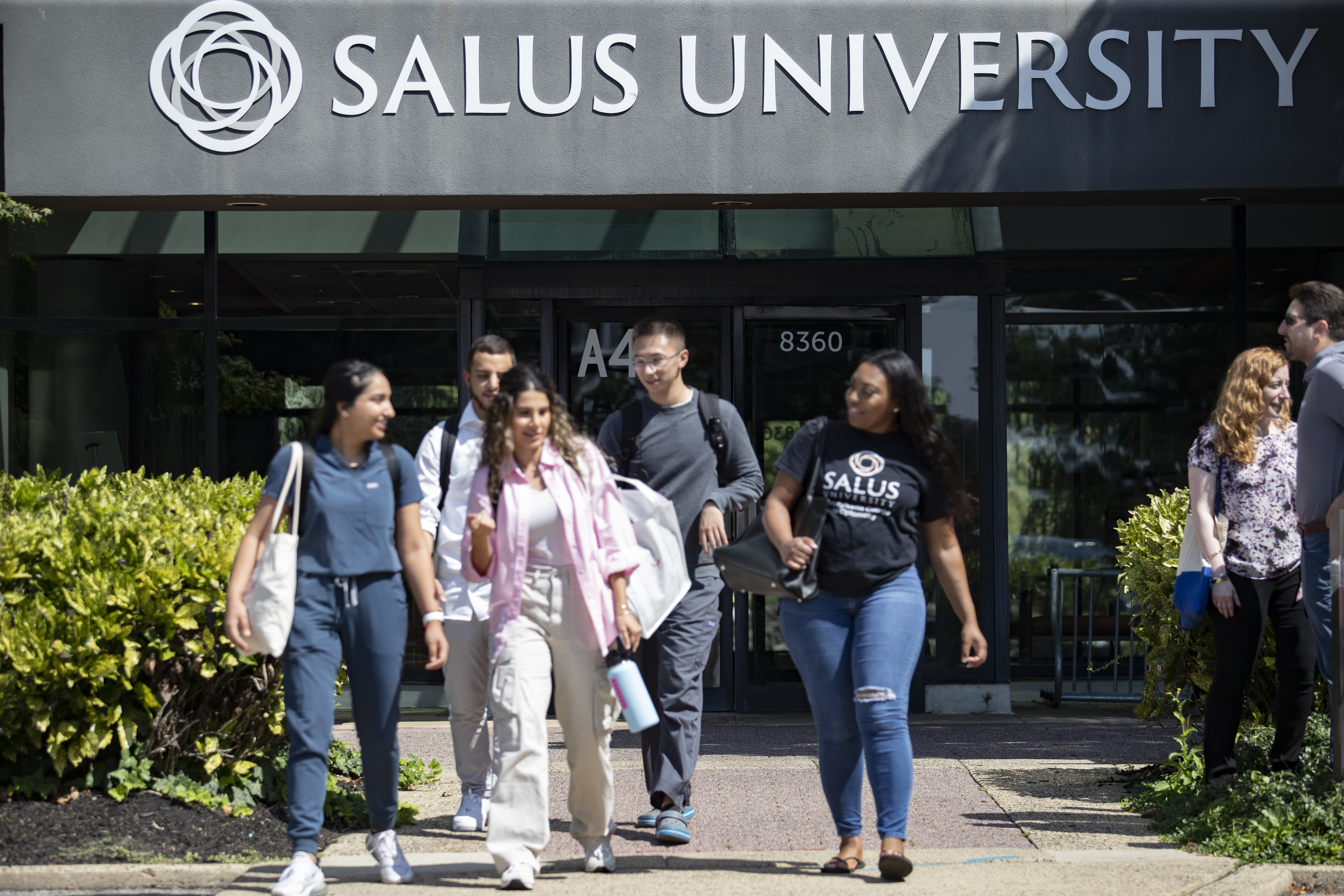 Students walking outside of the Salus main entrance