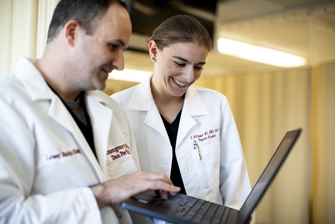 Two Salus University physician assistant faculty members looking at a laptop