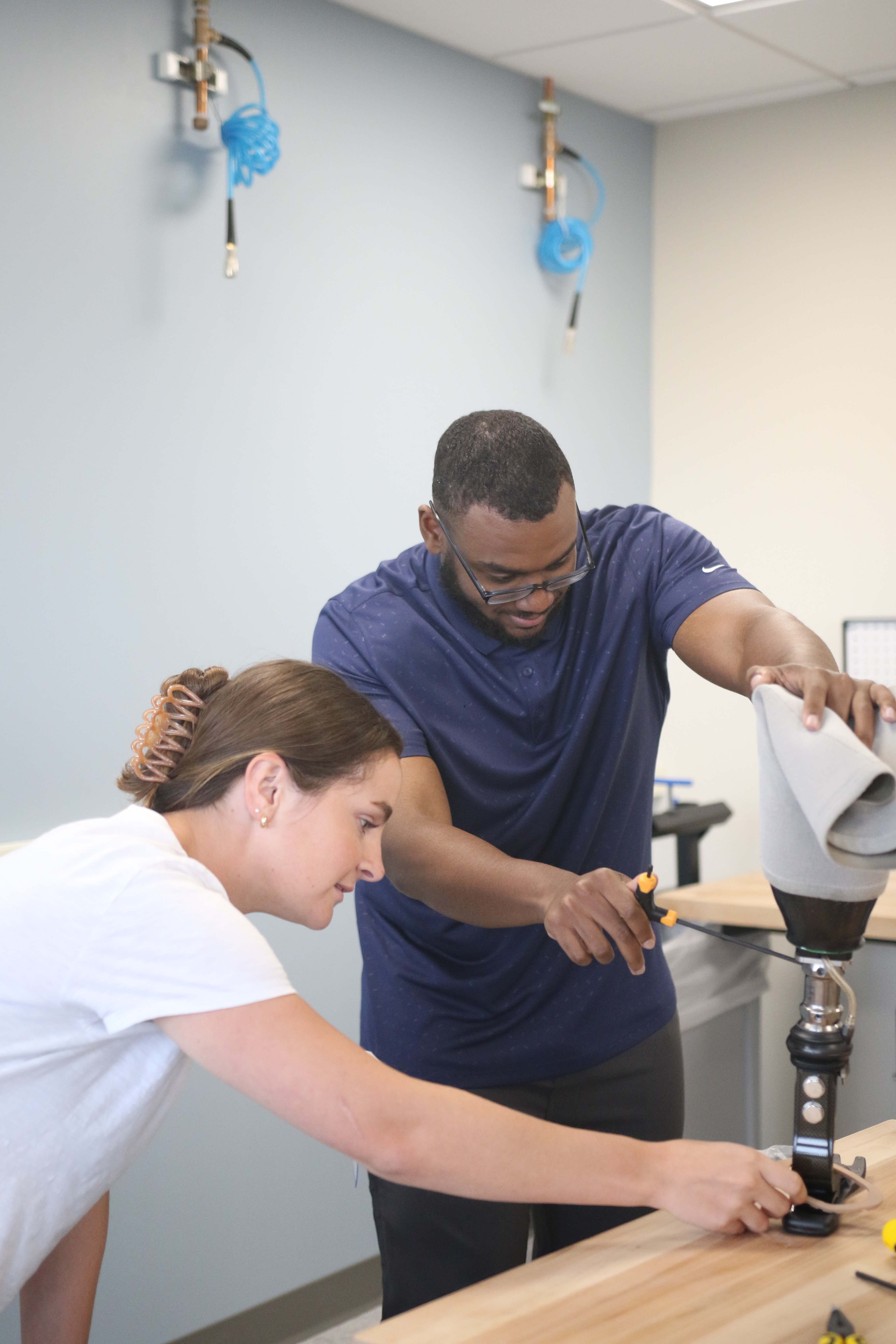 Antonio and another student adjusting a prosthetic