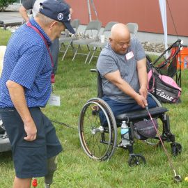 Man in wheelchair swinging a golf club