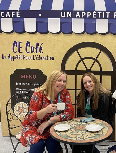 Two Salus members sitting at a table at a cafe smiling at the camera