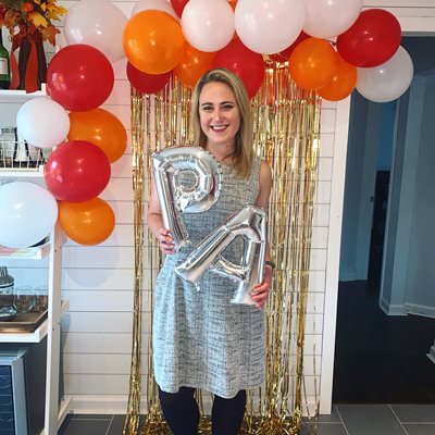 Ashlen Lawrence at an at home commencement celebration holding "PA" balloons