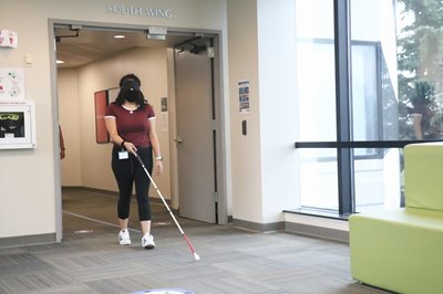 Student walking with a white cane