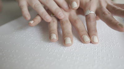 Two hands on top of braille