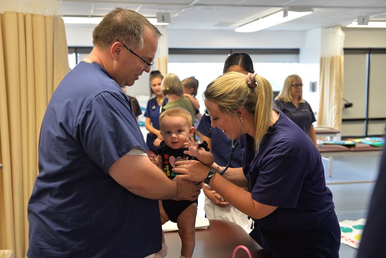 Adam Moore with Students in Pediatric Exam