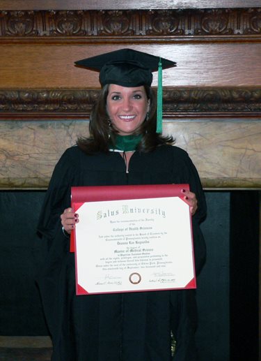 Deanna Reynolds wearing her graduation regalia and holding her diploma