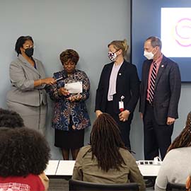 Dr. Paula Harmon Boone presenting the NOA School of the Year award to University officials during DEI Speaks event