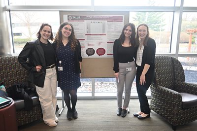 SLP students standing in front of their capstone poster