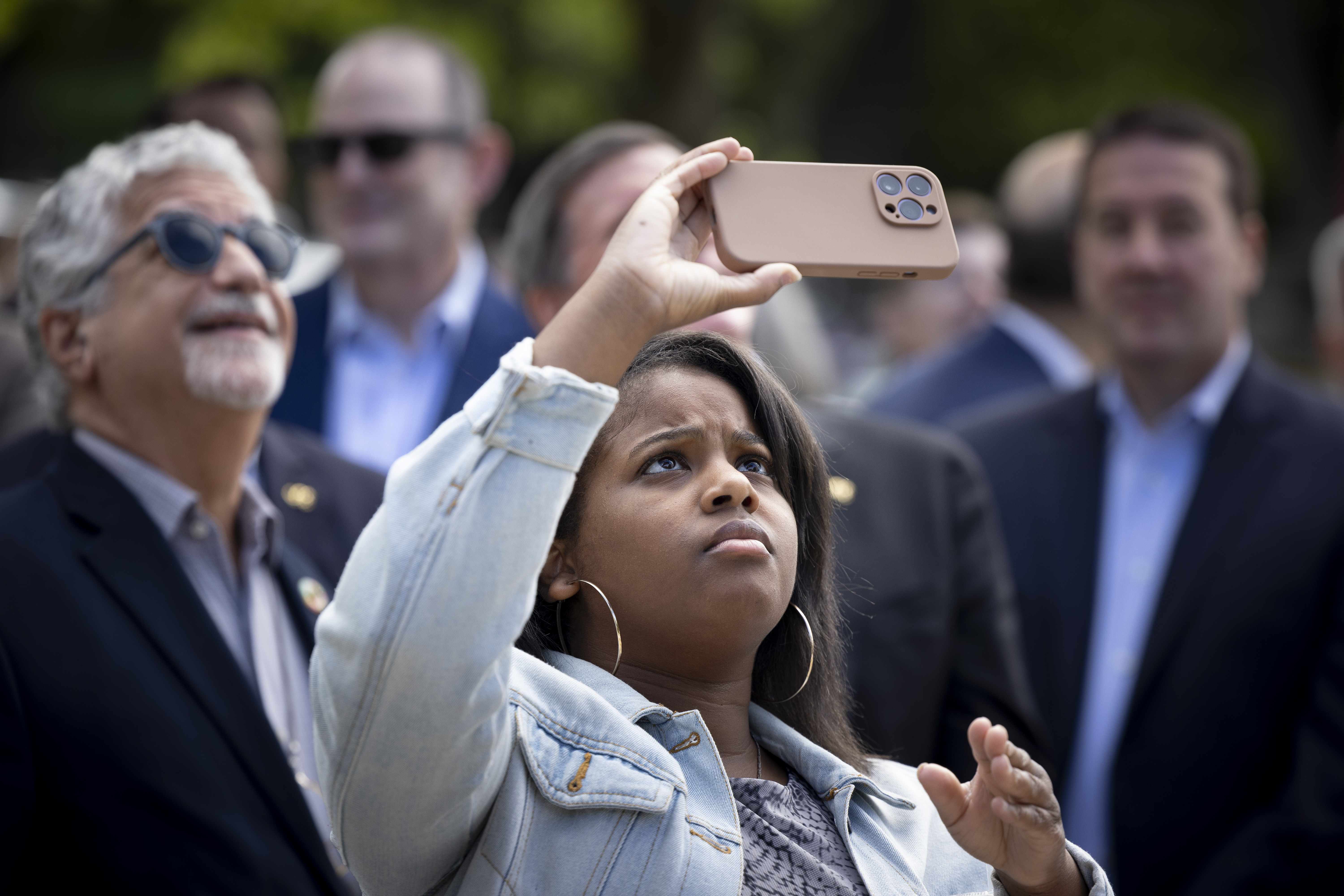 Woman photographing the flag raising