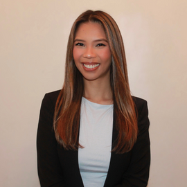 Gayle Caldamo headshot of her smiling wearing a light blue shirt and black blazer