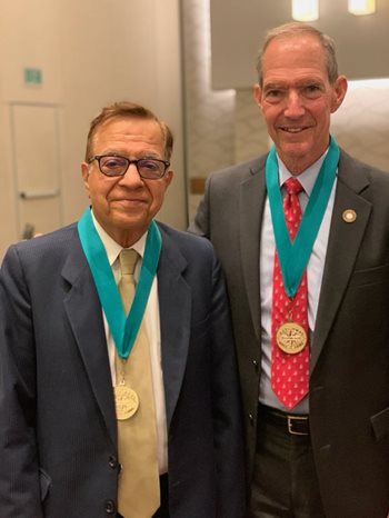 Drs. Verma and Mittelman wearing hall of fame medals at Optometry's Meeting 2021