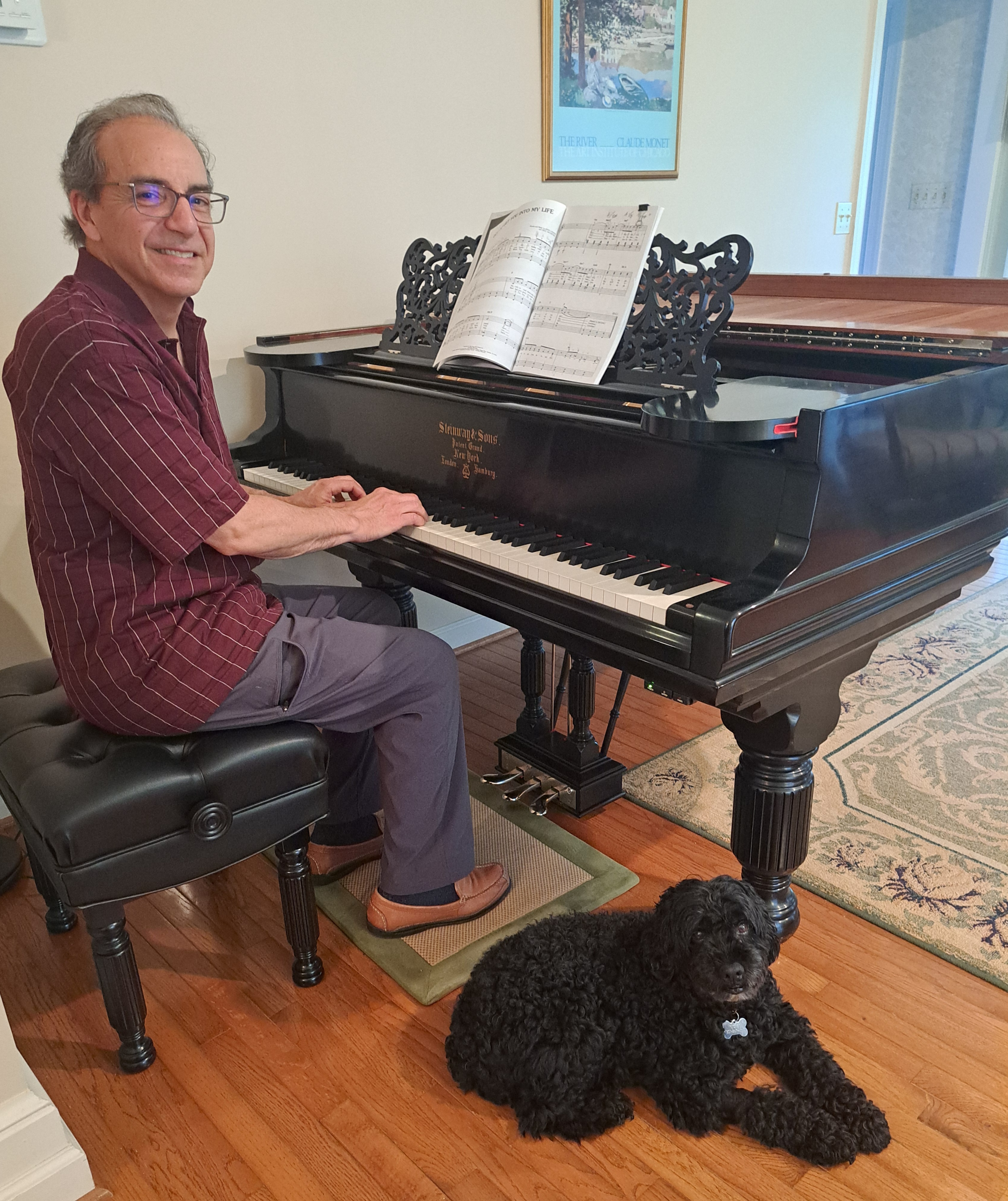 Jim Saviola at the piano with dog