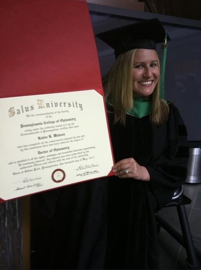 Kailee Watson wearing graduation regalia holding her diploma