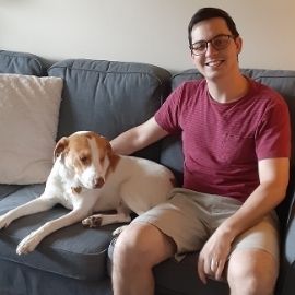 Dr. Nicholas Karbach and his dog sitting on a couch