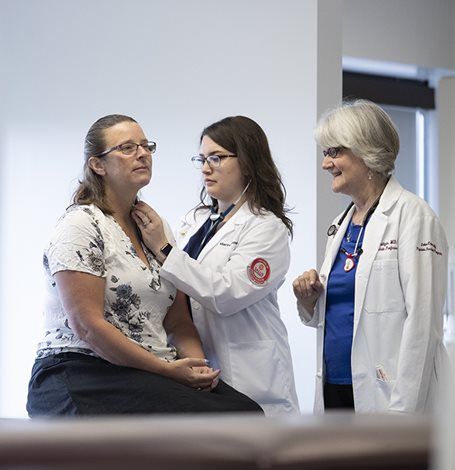 Physician Assistant student and faculty with a patient