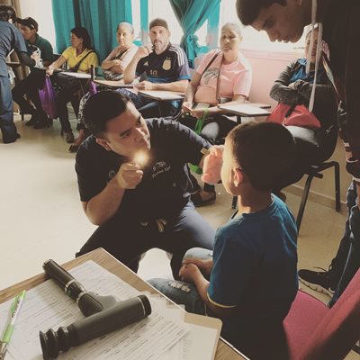 Dr. Higa providing an eye exam to a pediatric patient