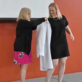 Student puts on her long white coat