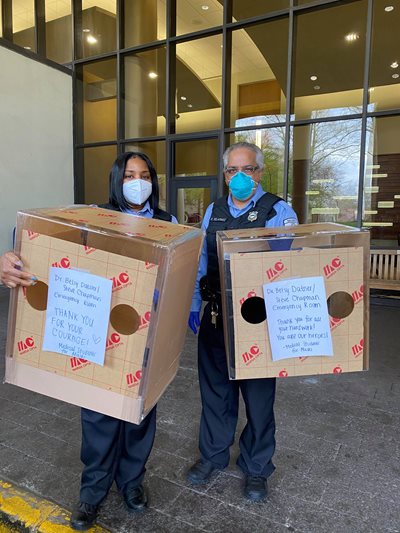 Two people holding donation boxes