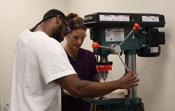 o&p professor teaching student how to use machine