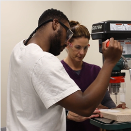 O&P professor teaching student to use machine