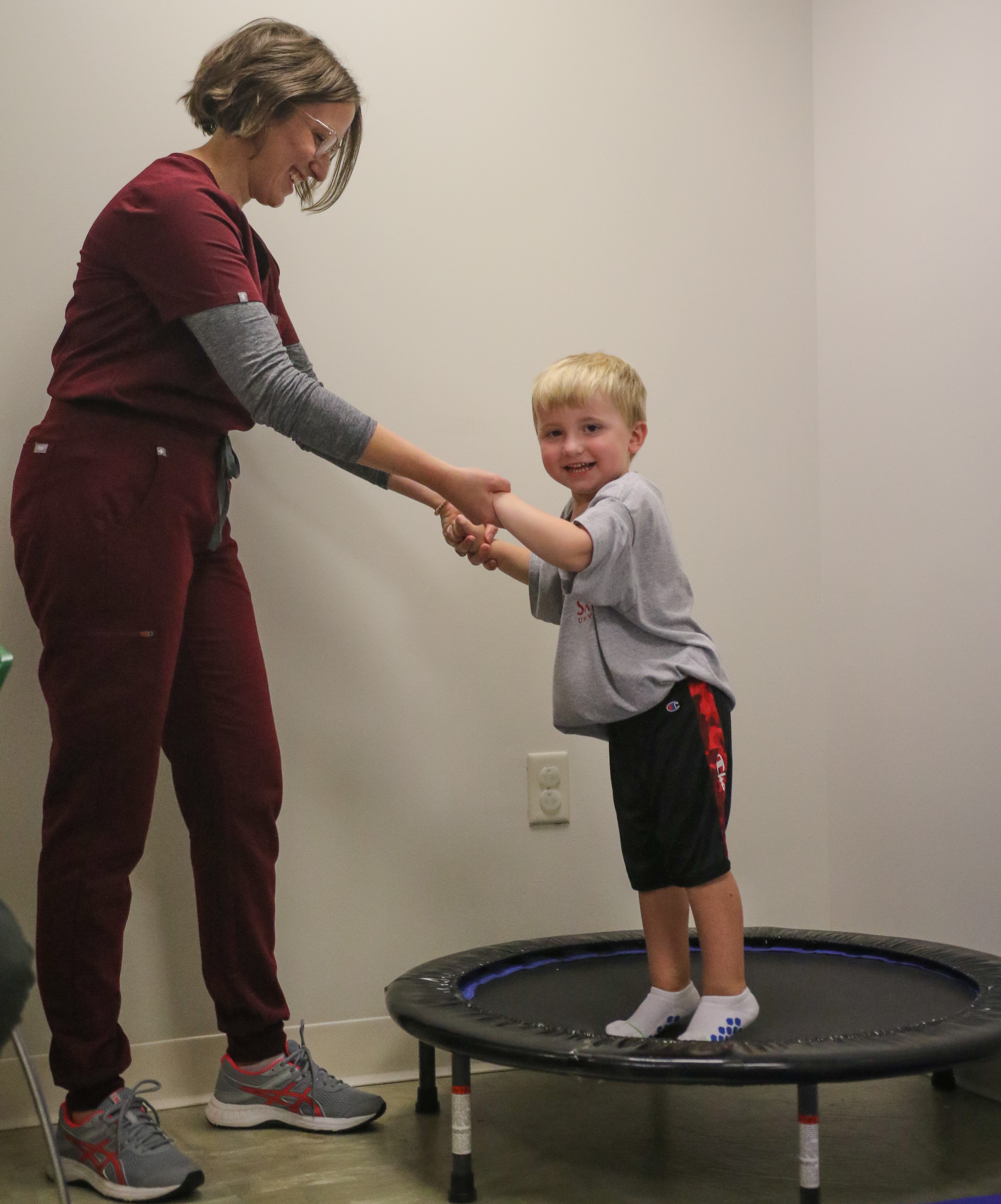 Briana Brim and child conducting OT services 