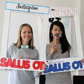 students holding OT month sign