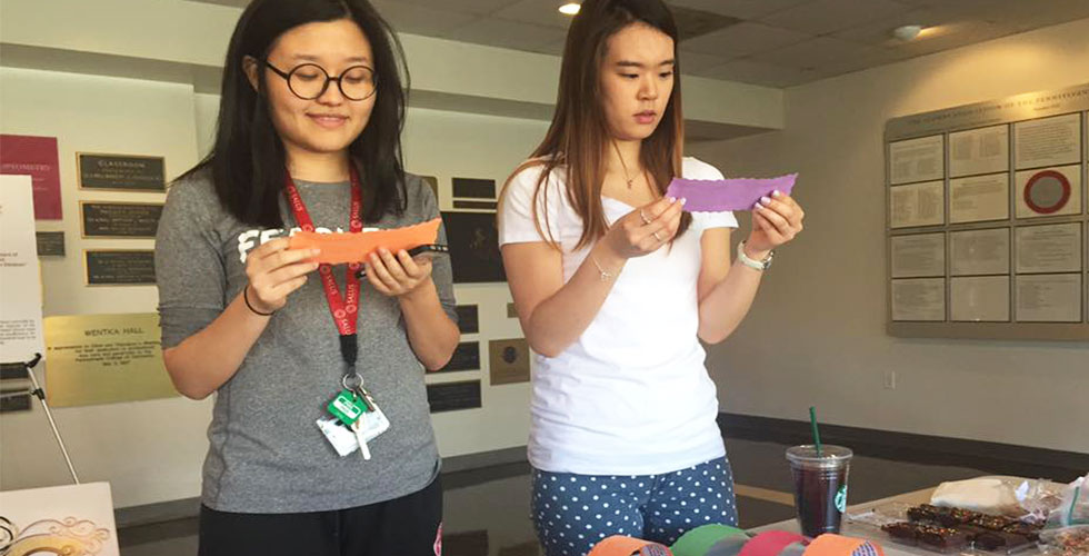 students holding pieces of paper