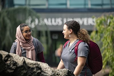 Two students walking outside of Salus University talking