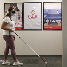 Student walking with long white cane