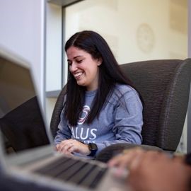 Student sitting with laptop in lounge