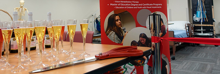 champagne and giant scissors at ribbon cutting event