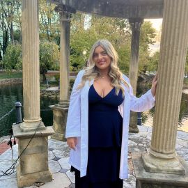 Shannon McCabe stands outside Salus University in her white coat after her white-coat ceremony