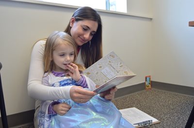 SLP student reading to a pediatric patient