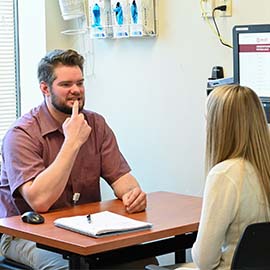 Photo of a male SLP student working with a patient.