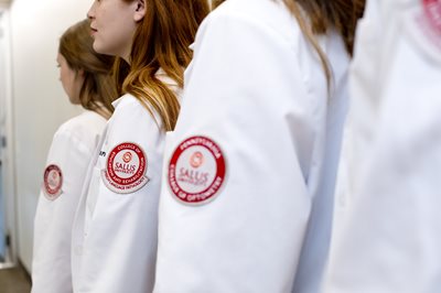 Students wearing white coats with the Salus patches