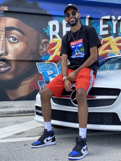 Umar sitting on the hood of a car