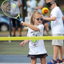 little girl playing tennis