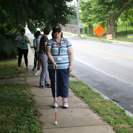 Student practicing with a white cane