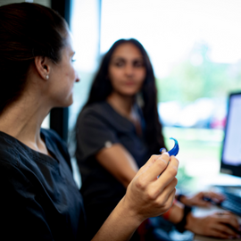 audiologist holding hearing aid