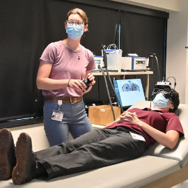 Instructor treats patient lying on table