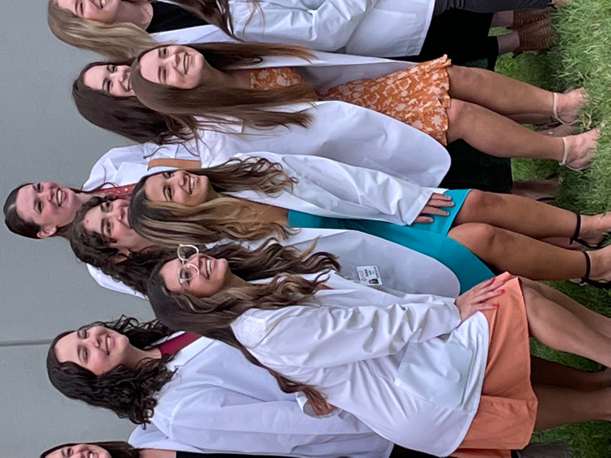 Group of students taking a photo in their white coats