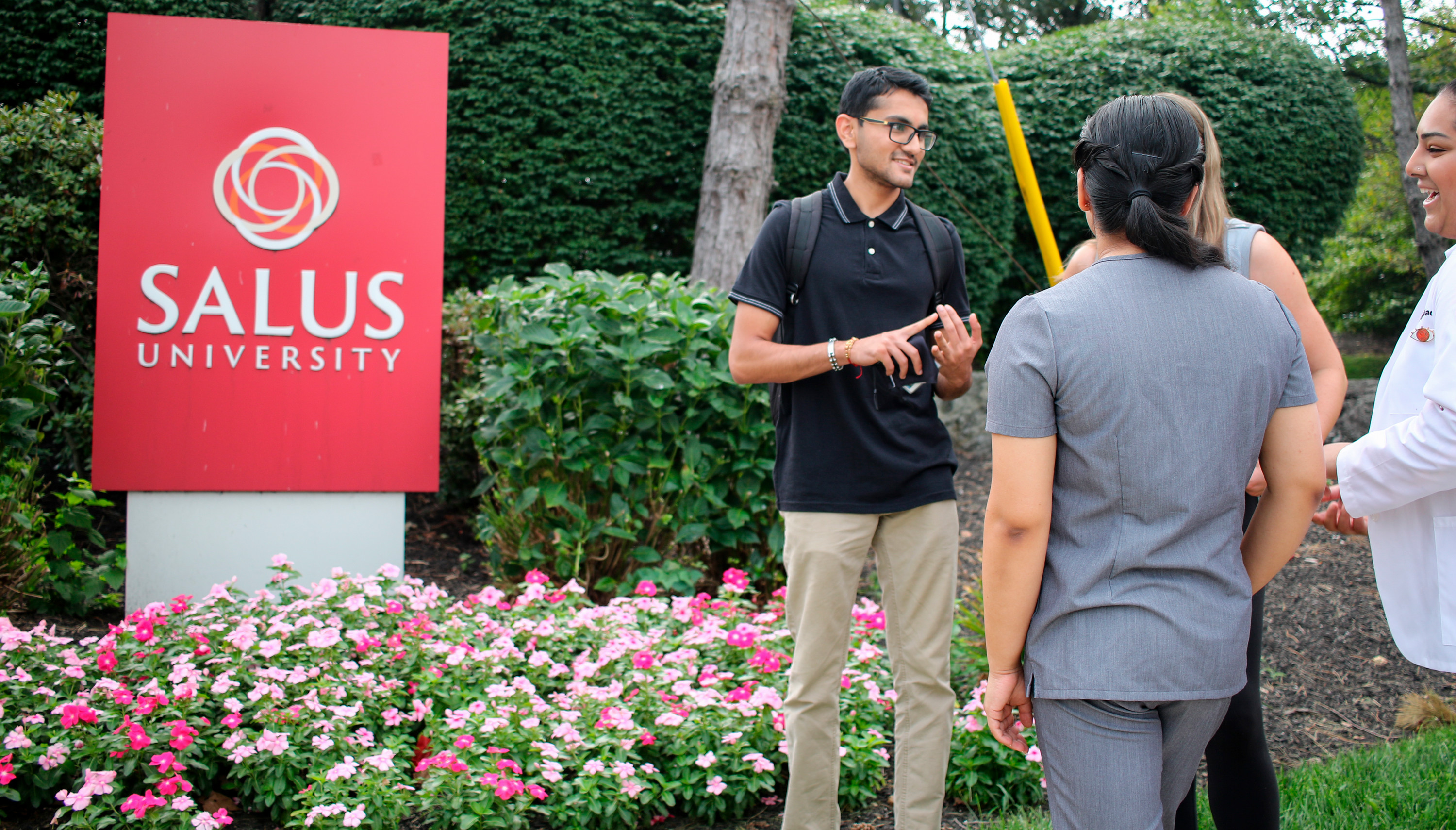 students standing outside salus sign