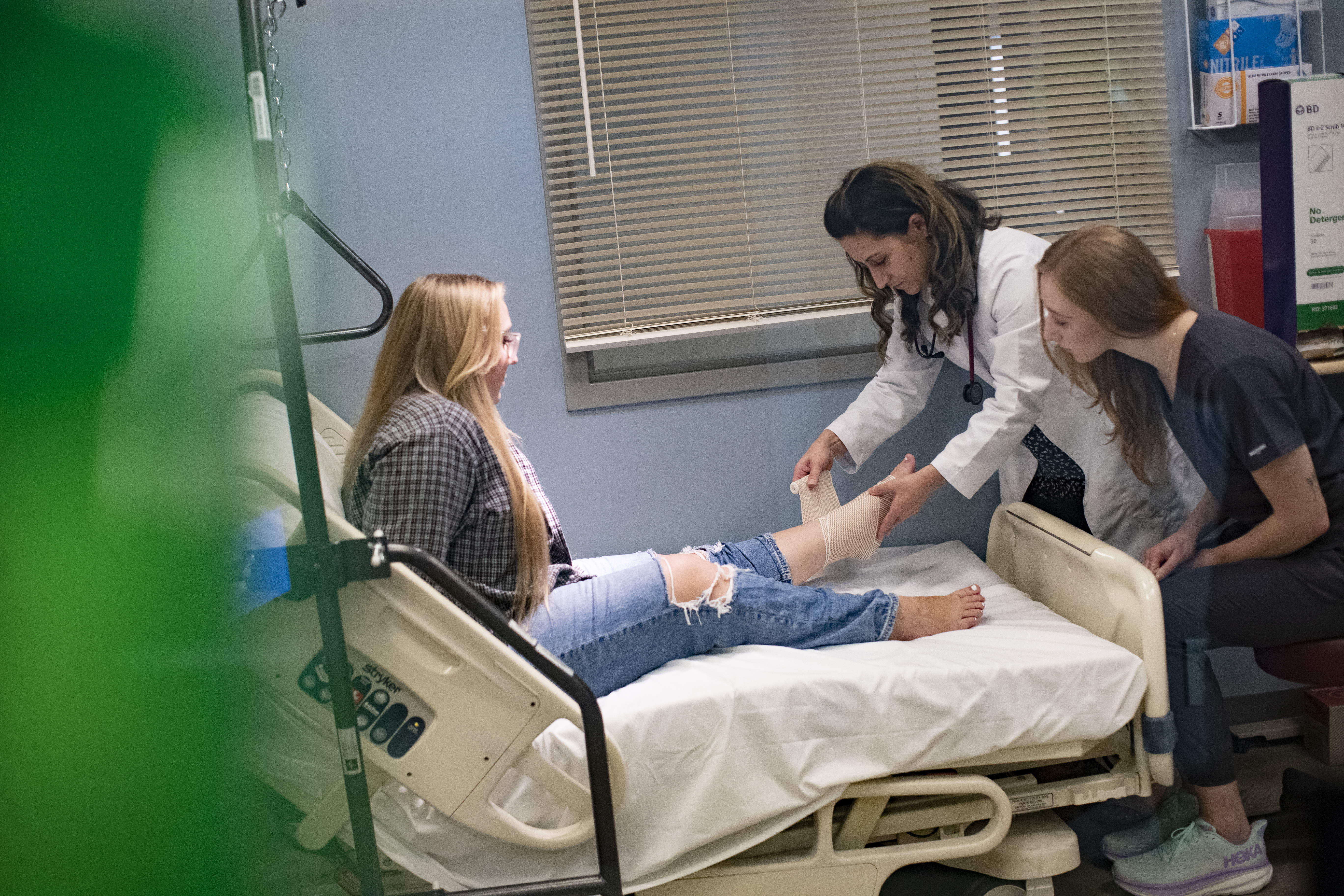 PA student and faculty wrapping a patient's ankle