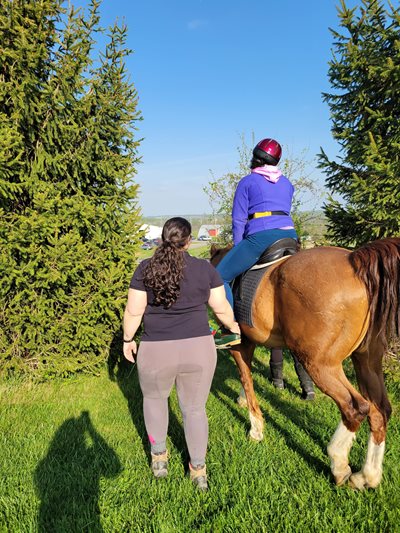 OT patient riding a horse with MSOT assisting