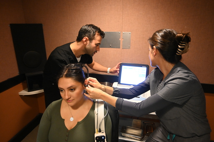 Aaron Roman in lab with patient and tech