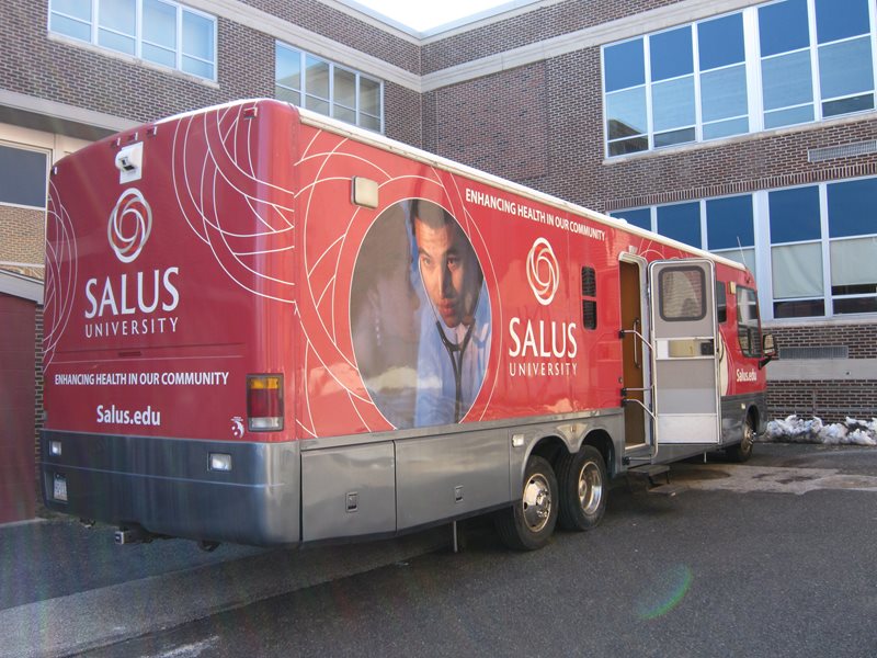 The Big Red Bus parked outside of a school 