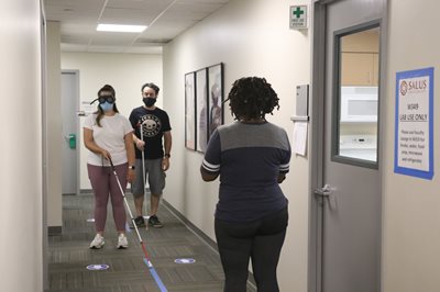 BLVS students working together using a white cane